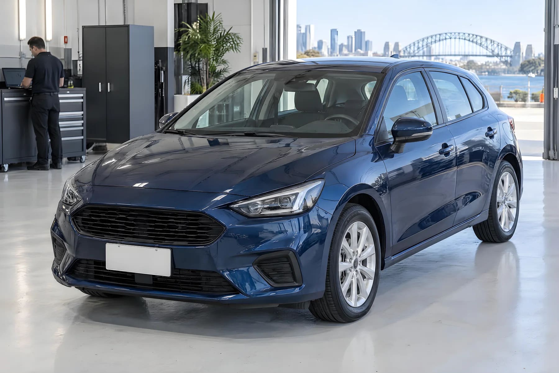 The same dark blue hatchback after repair, with an aligned bonnet and a new headlight, in a workshop handover bay