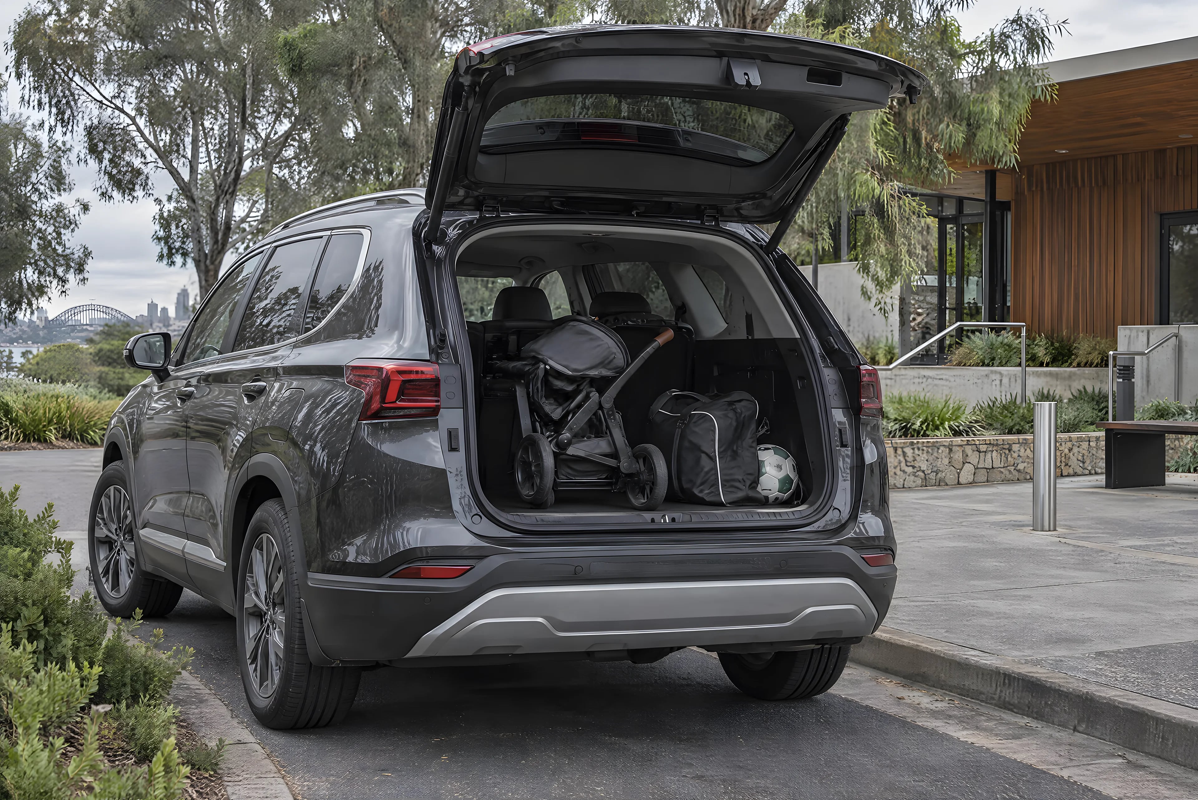 A graphite family SUV with its boot open outside a leafy Sydney community centre